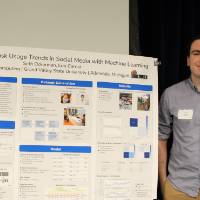 Student stands next to project